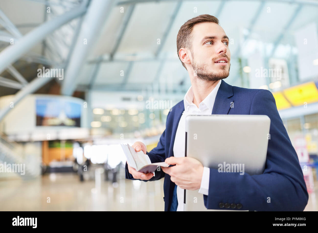 Jeune homme d'affaires en mission dans la région de terminal de l'aéroport avec ordinateur portable et livre de rendez-vous Banque D'Images