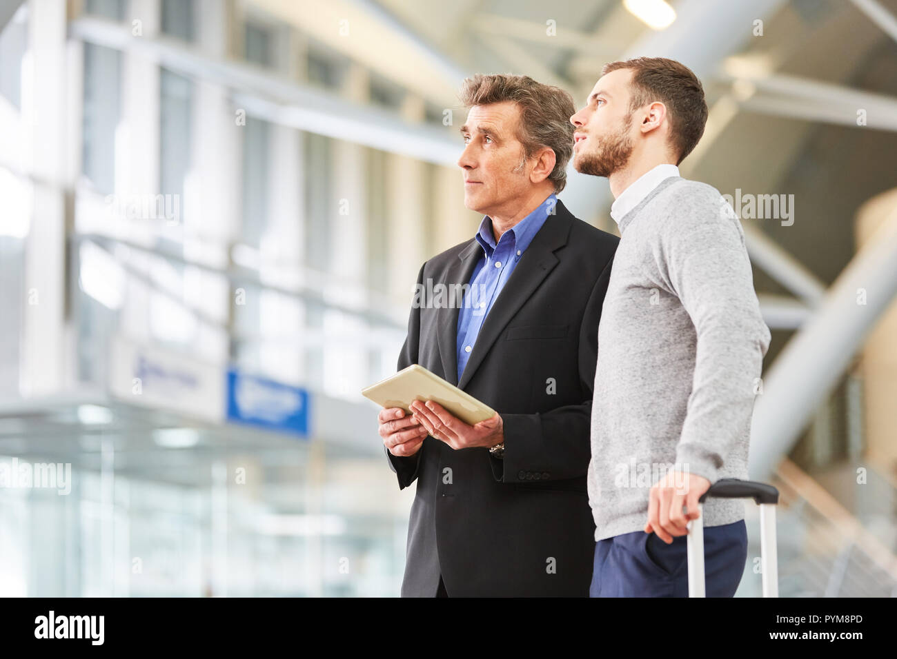 Deux hommes d'affaires ou les gestionnaires de terminal de l'aéroport à l'aide de l'ordinateur tablette avant d'affaires Banque D'Images