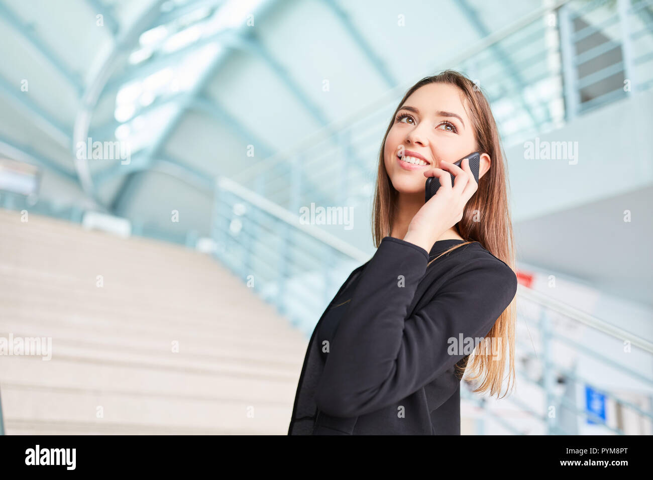 Young businesswoman en voyage d'affaires est de téléphoner avec le smartphone en terminal de l'aéroport Banque D'Images