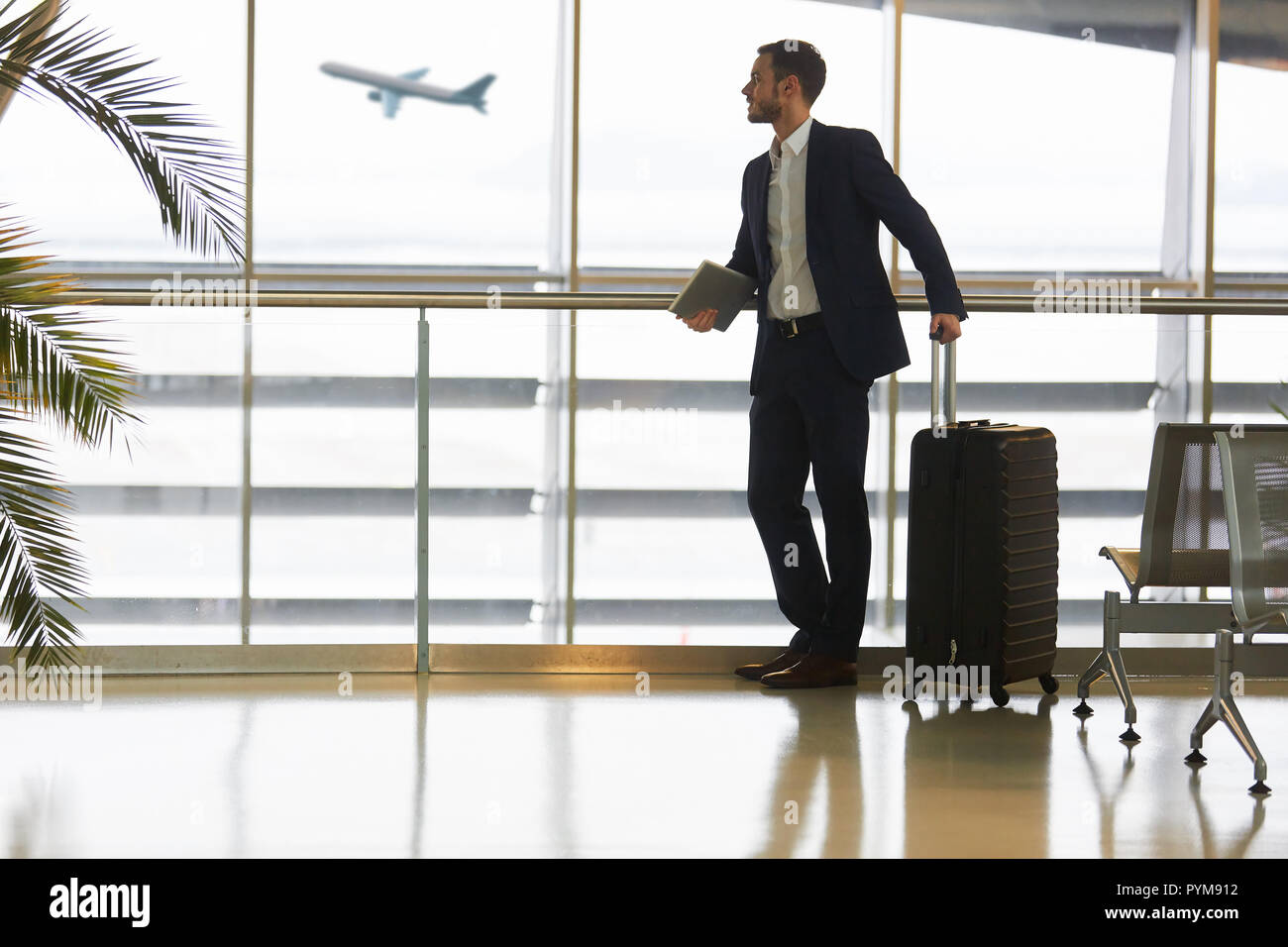 L'homme d'affaires avec assurance et tablette ordinateur tout en changeant de terminal de l'aéroport Banque D'Images