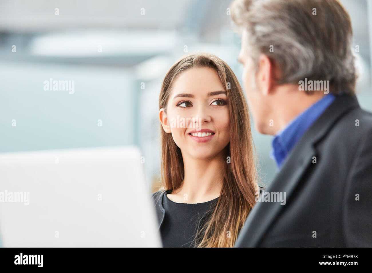 Jeune femme d'affaires parle de son voyage d'affaires avec une collègue dans le terminal de l'aéroport Banque D'Images