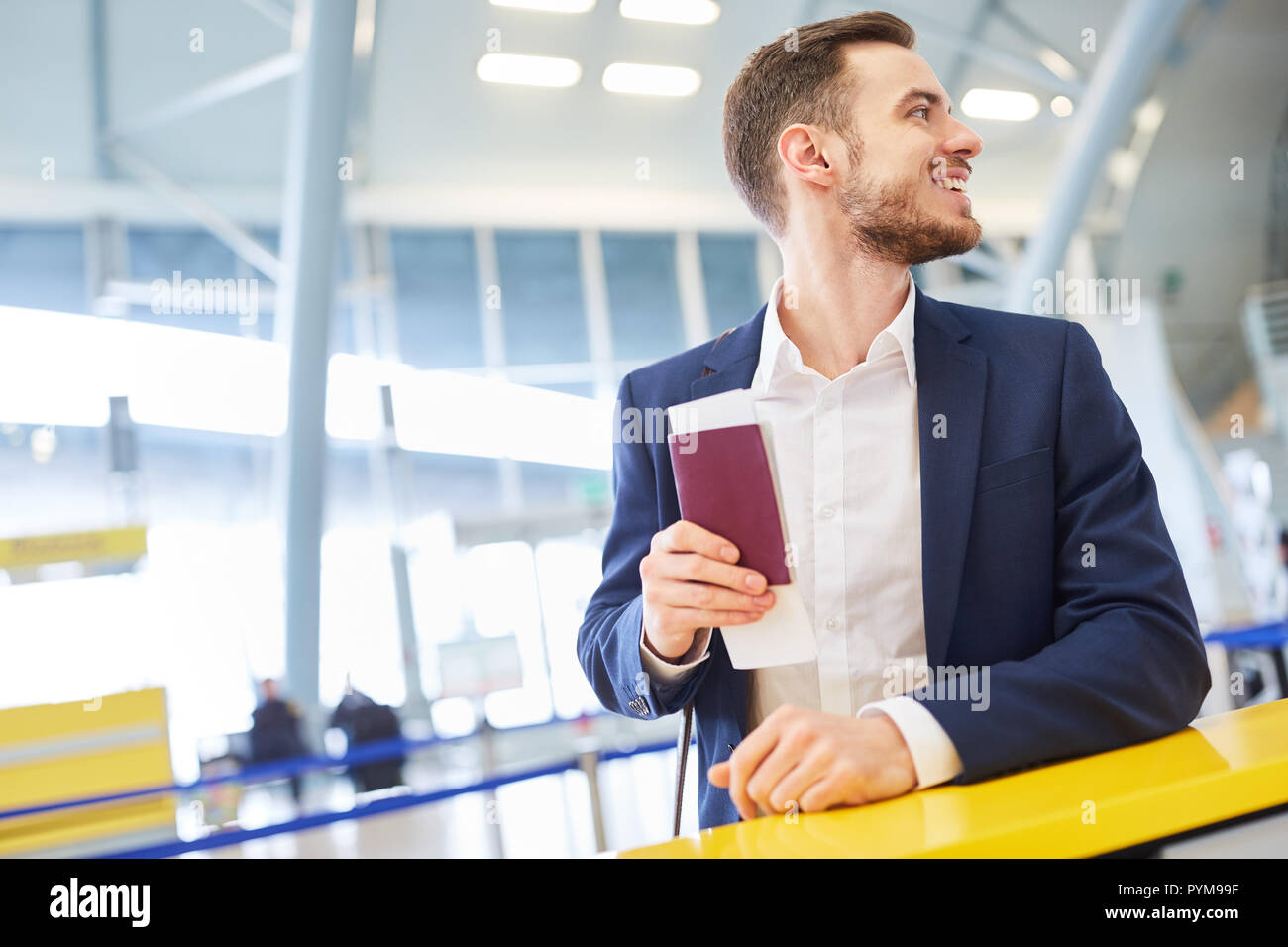 L'homme d'affaires dans le terminal de l'aéroport voyage d'affaires tout en changeant avec passeport Banque D'Images