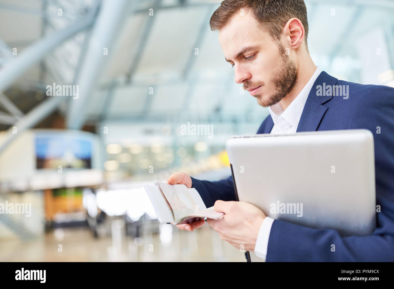 Jeune manager en voyage d'fouille dans son carnet de rendez-vous au terminal de l'aéroport Banque D'Images