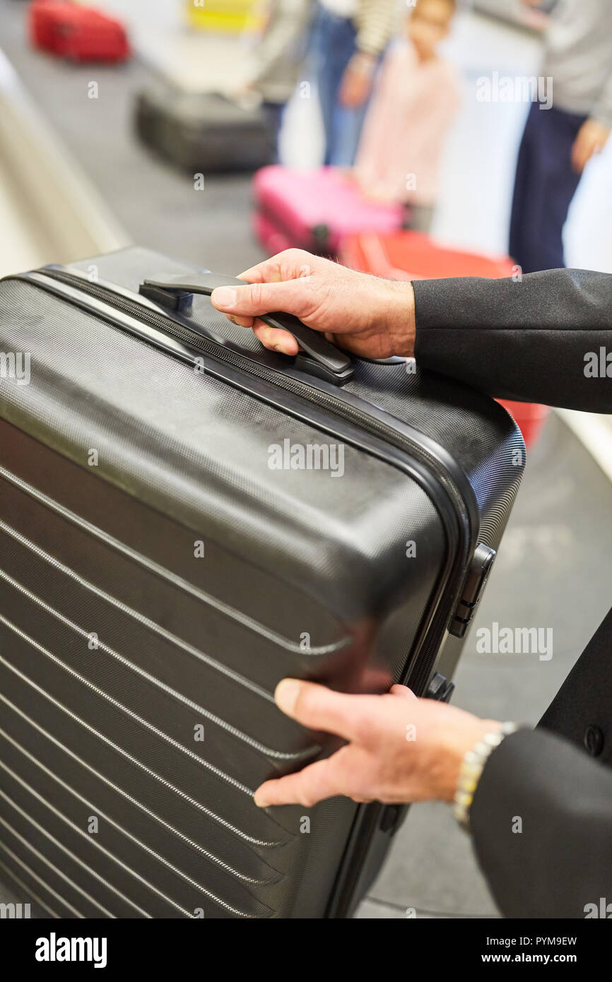 Valises et sacs sont ramassés par les voyageurs au système de manutention des bagages après le voyage Banque D'Images