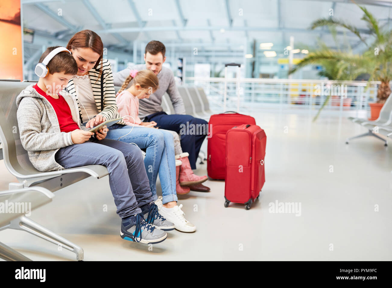 Famille avec enfants en terminal de l'aéroport doit attendre pour vol de correspondance dans l'aire de repos Banque D'Images