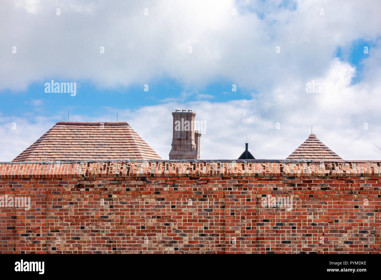 Mur de briques avec les toits des bâtiments de l'autre côté Banque D'Images