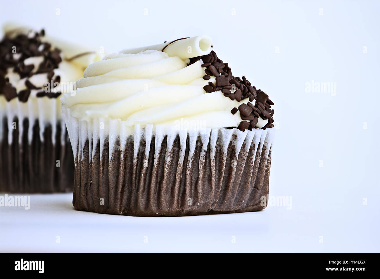 Joli petit gâteau au chocolat avec glaçage buttercream. Décoré avec des copeaux de chocolat blanc et de chocolat noir. Banque D'Images