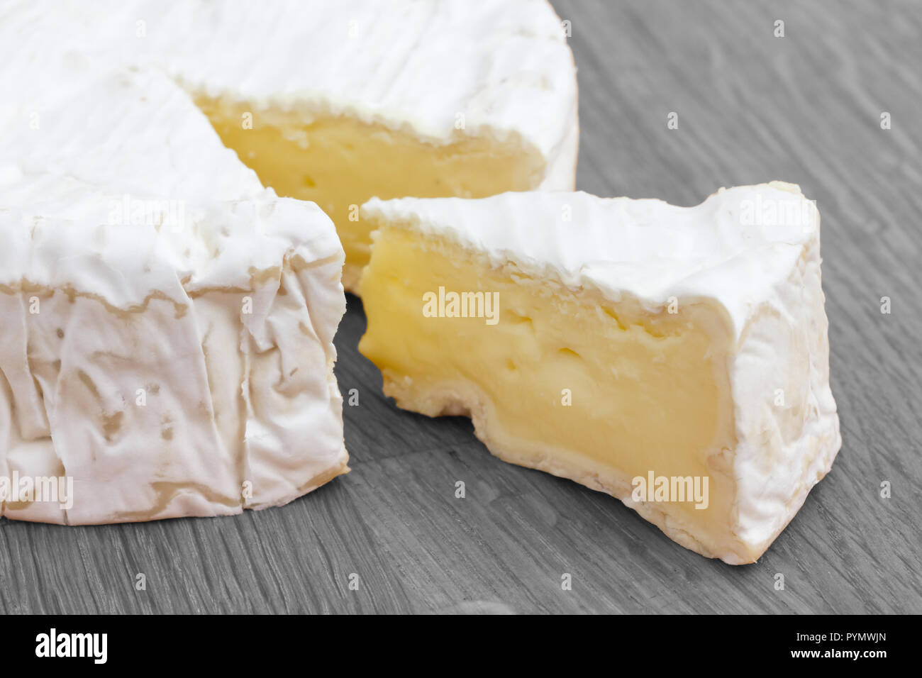 Tranche de fromage blanc coupé d'un grand rond sur une surface en bois. Banque D'Images