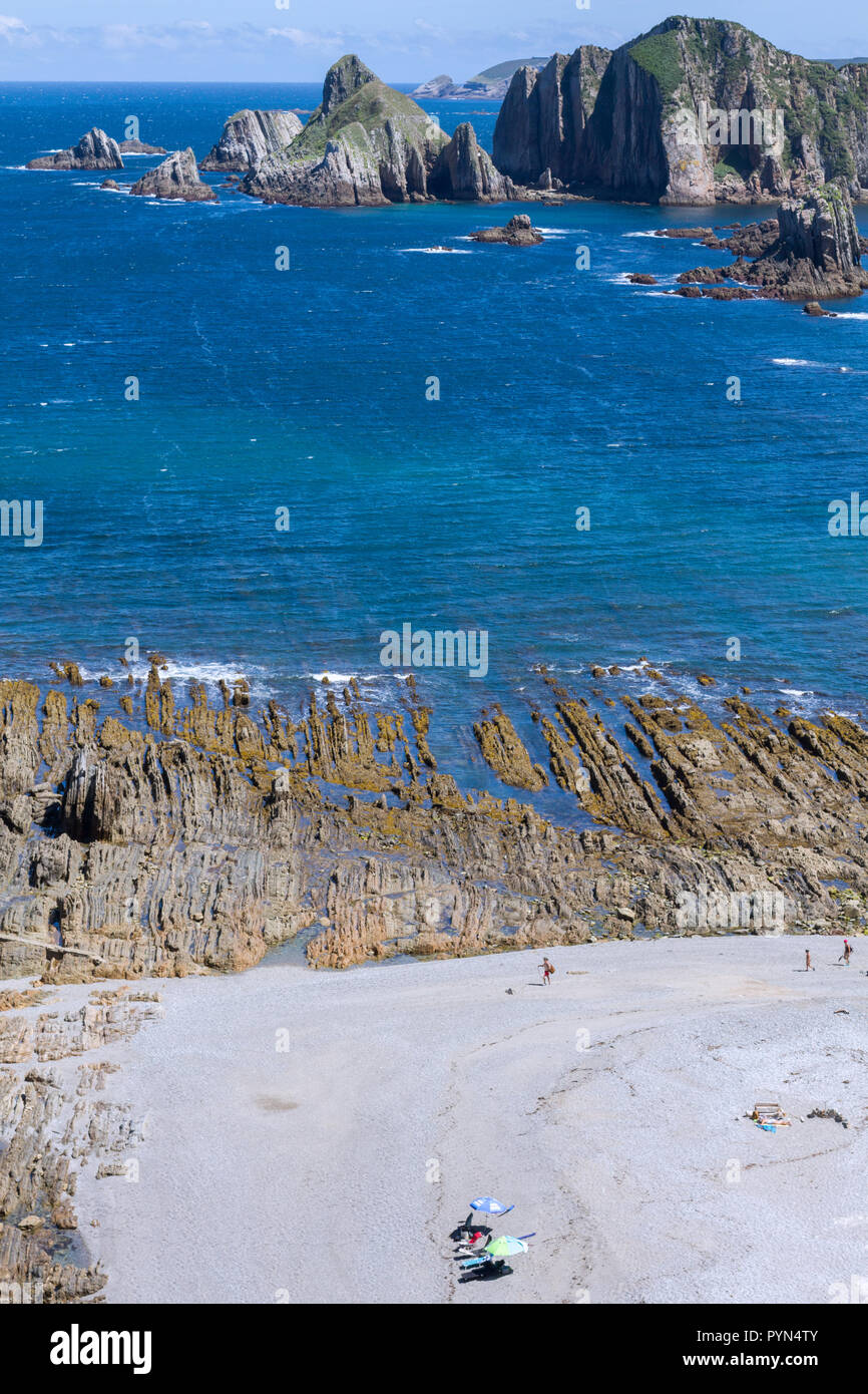 Gueirua beach, Asturias, Espagne. Vue aérienne générale de plage rocheuse avec vagues et deux chaises de plage vide dans le sable blanc. Banque D'Images