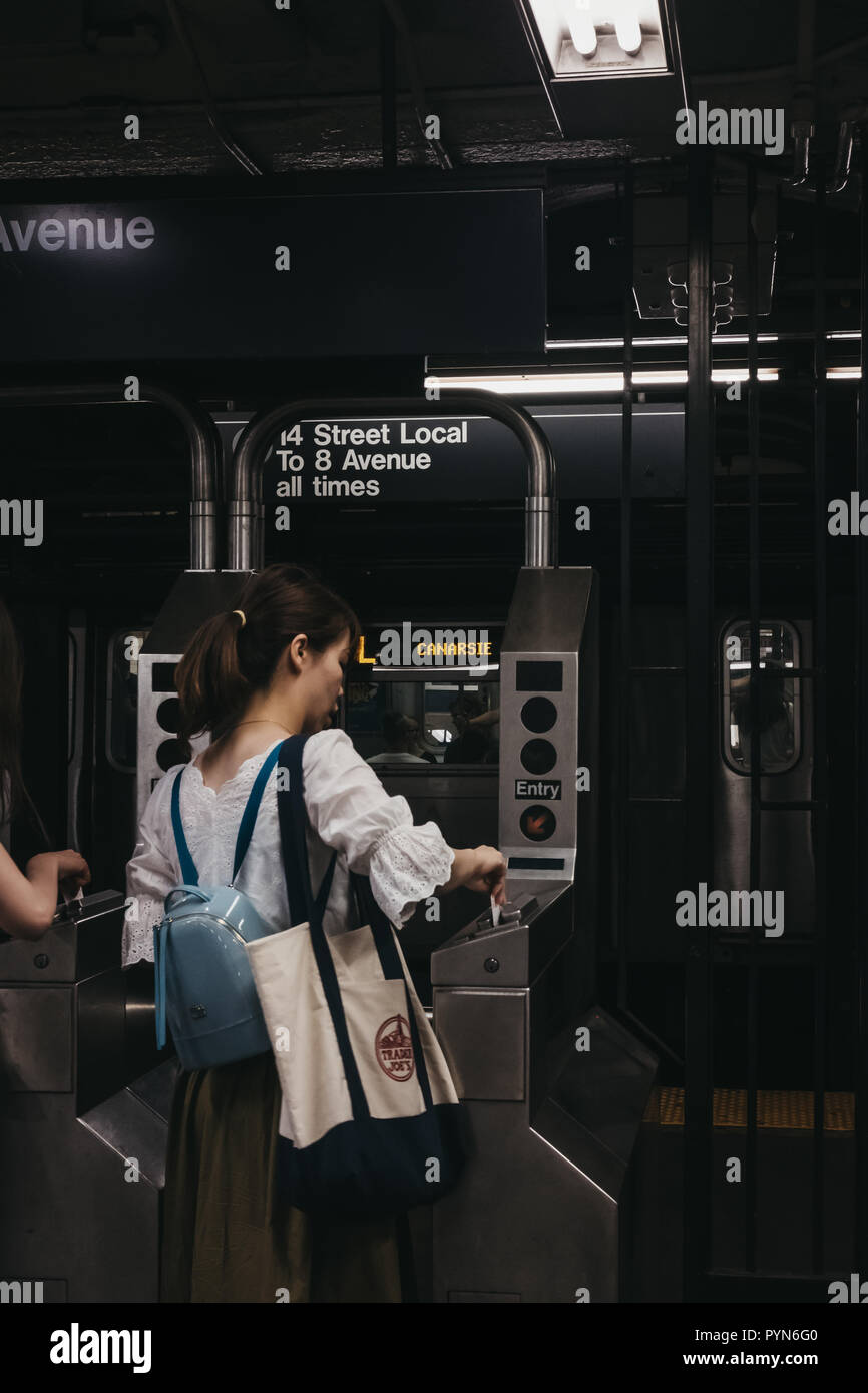 New York, USA - 2 juin 2018 : femme balayant carte de métro la station de métro pour entrer à New York, le train sur l'arrière-plan. New York City Subway est une des t Banque D'Images