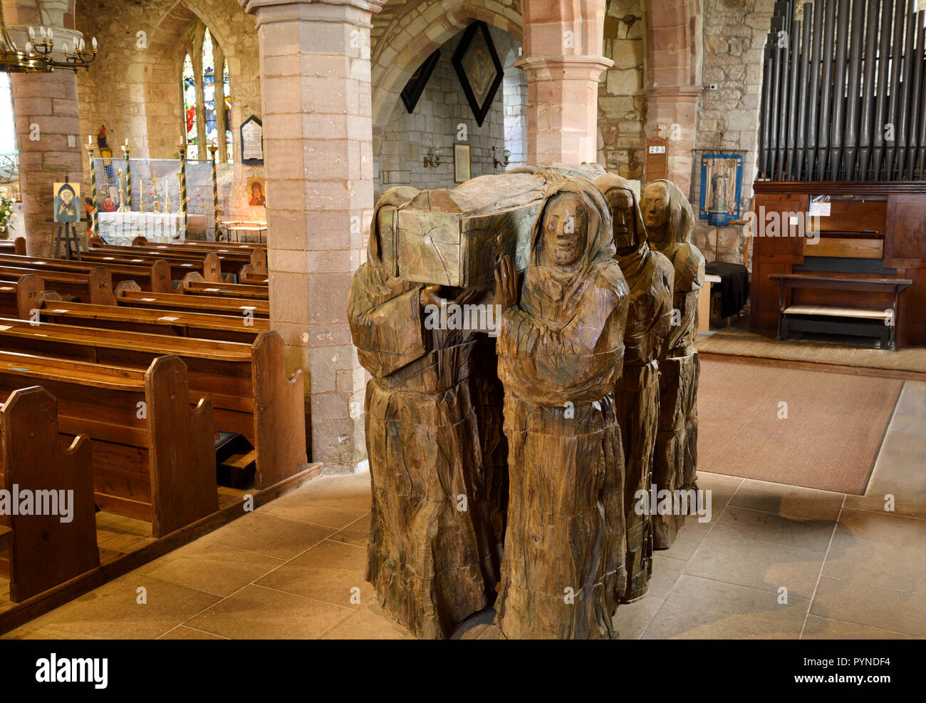 La sculpture sur bois de moines portant dead monk en cercueil dans la nef de l'église paroissiale de Sainte Marie la Vierge sur l'Île Sainte de Lindisfarne en Angleterre Banque D'Images