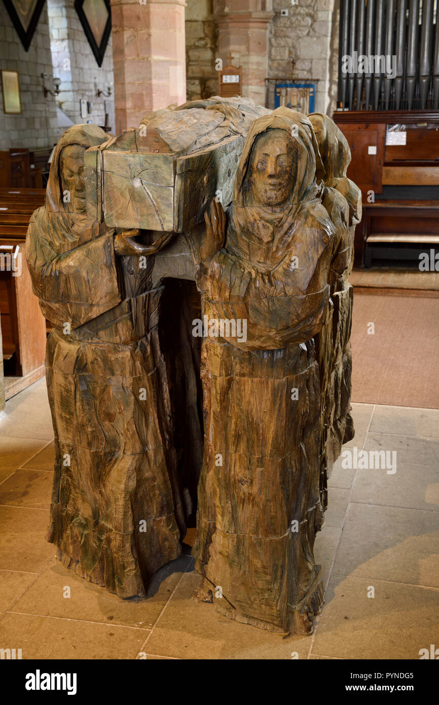 La sculpture sur bois de moines exerçant son frère mort dans le cercueil dans l'église paroissiale de Sainte Marie la Vierge sur l'Île Sainte de Lindisfarne England UK Banque D'Images