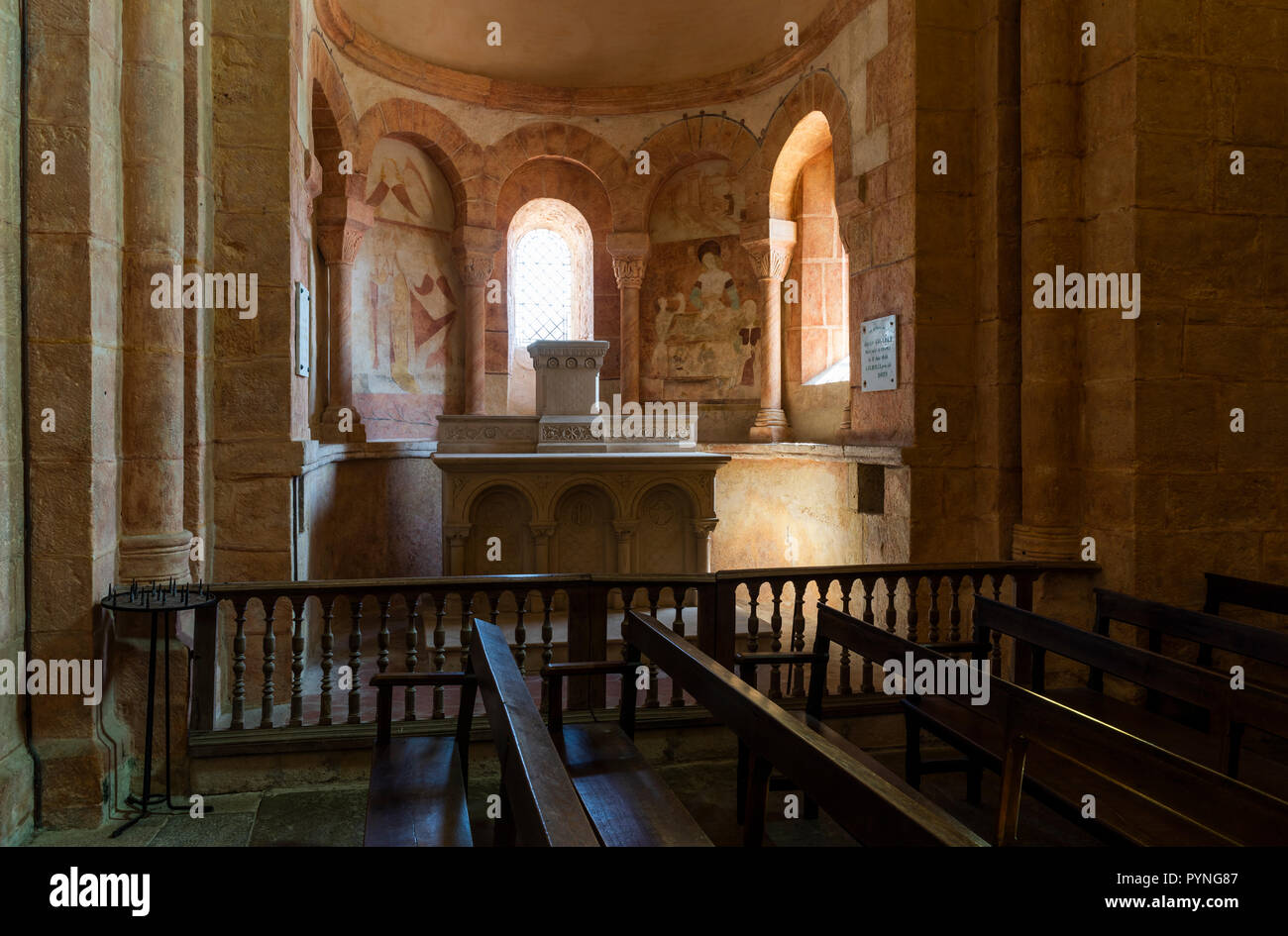 Gourdon, France - 3 août 2018 : Intérieur avec la couleur rose, des banquettes en bois et d'énormes piliers de l'église romane à Gourdon, Saône-et-Loire, France Banque D'Images
