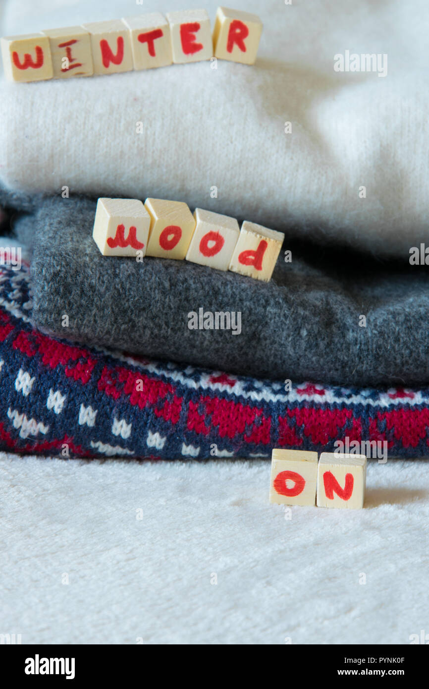 Pulls en laine avec 'hiver' sur l'humeur, mode texte concept saisonniers Banque D'Images