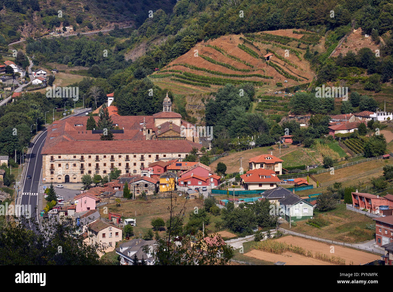 Monasterio de Corias (aujourd'hui un Parador) dans la vallée du Rio Narcea avec vignobles en terrasses sur les pentes. Cangas del Narcea, Asturias, Espagne. [Cang Banque D'Images