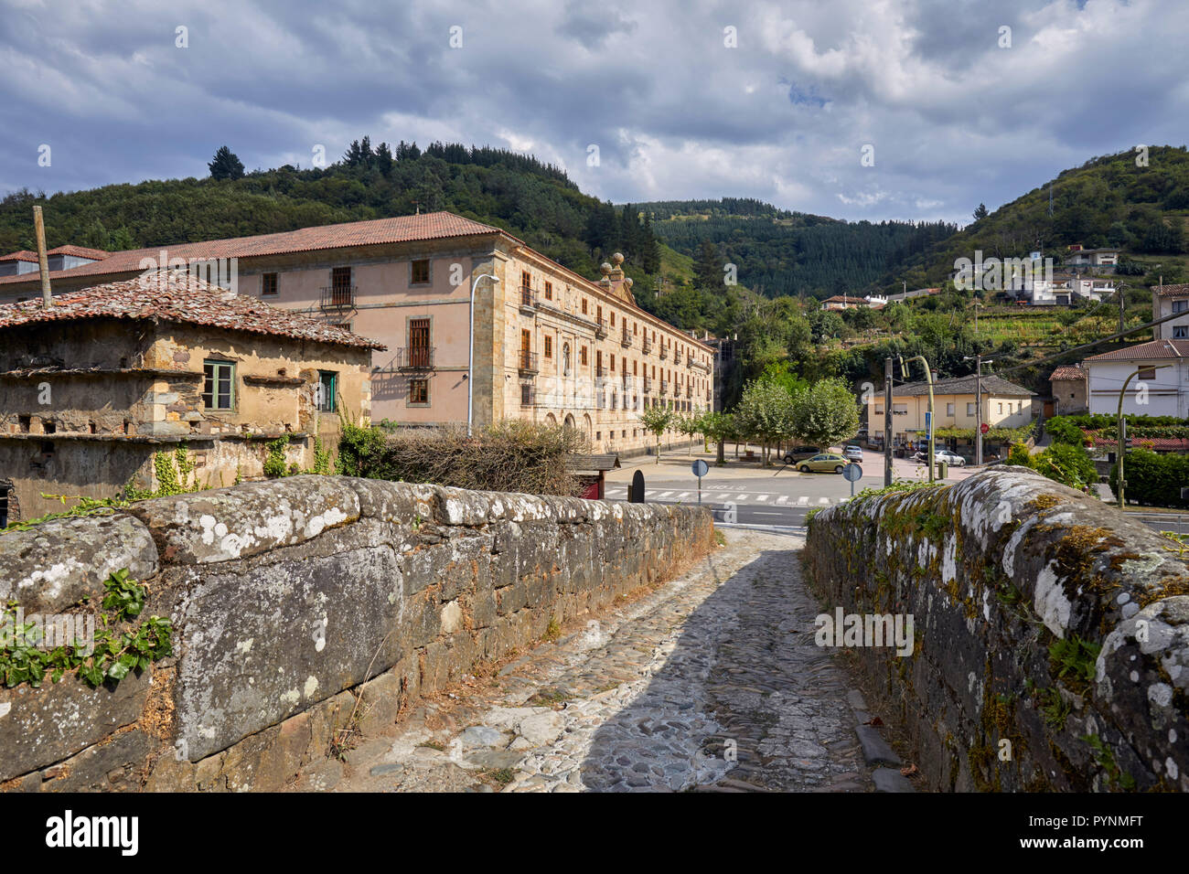 Monasterio de Corias (aujourd'hui un Parador) dans la vallée du Rio Narcea avec vignobles en terrasses sur les pentes - vue de El Puente de Corias. Cangas d Banque D'Images