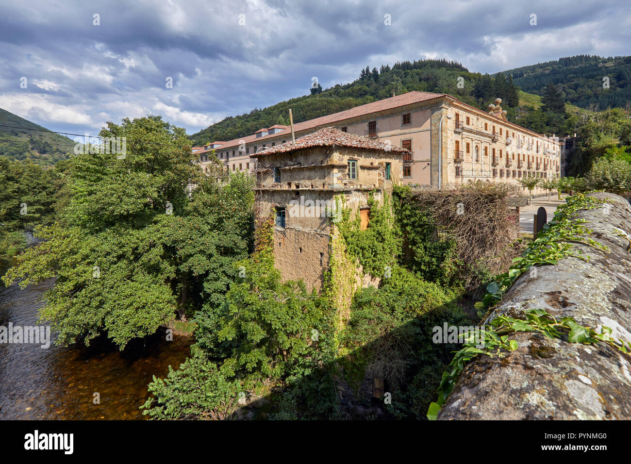 Monasterio de Corias (aujourd'hui un Parador) dans la vallée du Rio Narcea avec vignobles en terrasses sur les pentes - vue de El Puente de Corias. Cangas d Banque D'Images