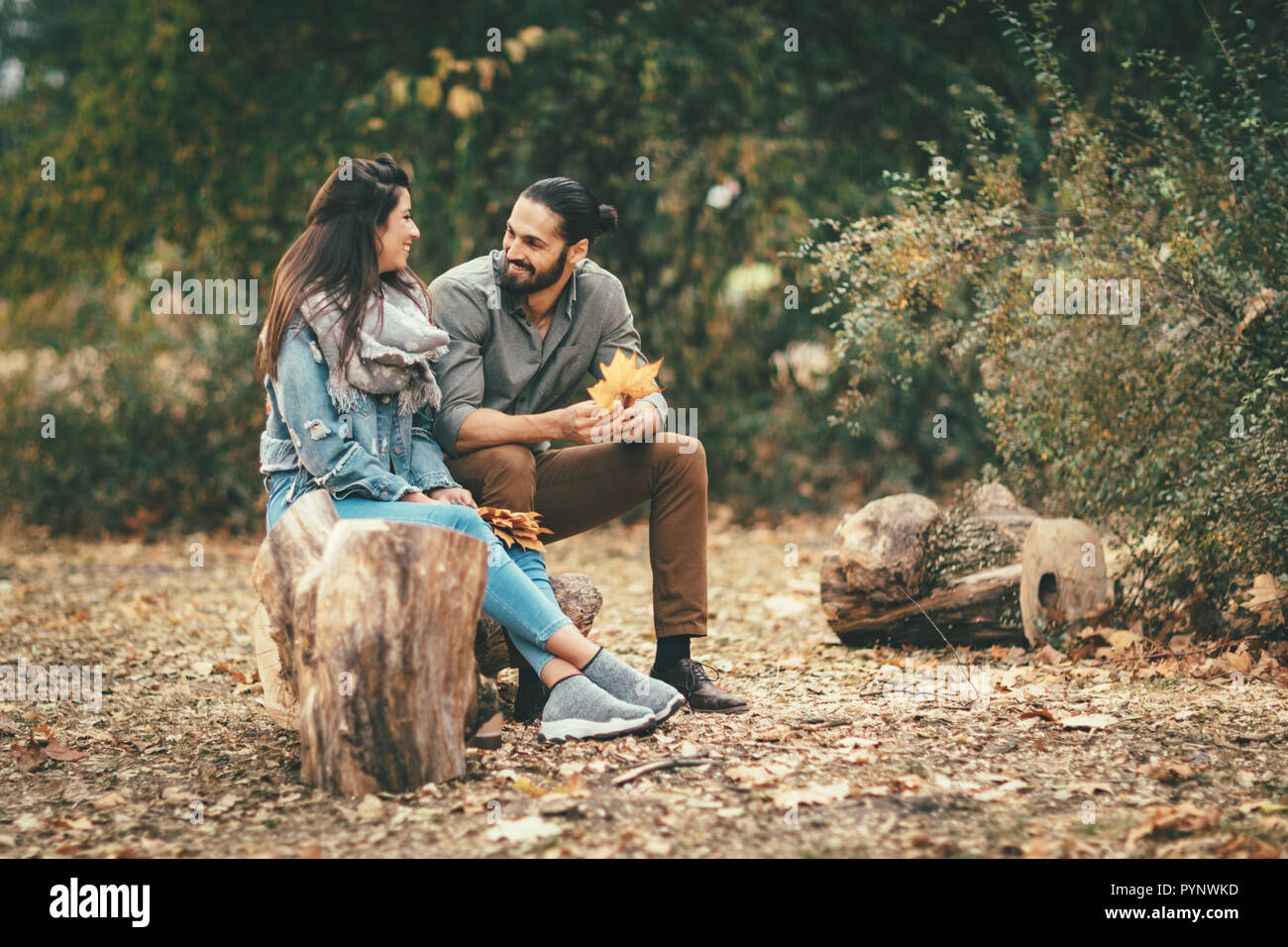 Beautiful smiling couple enjoying sunny city park de couleurs d'automne à l'autre. Ils ont du plaisir avec des feuilles jaunes. Banque D'Images