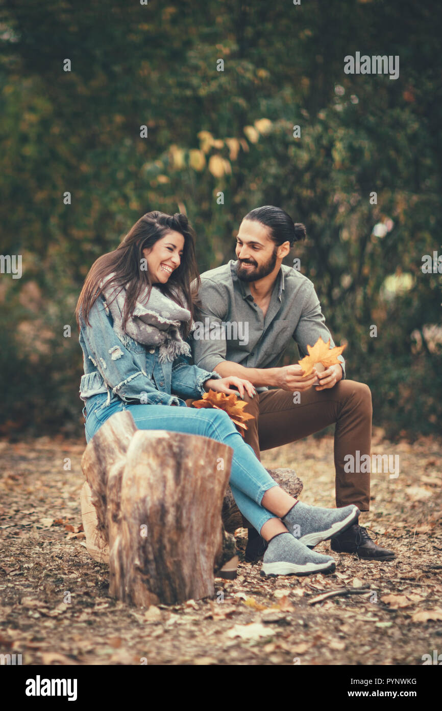 Beautiful smiling couple enjoying sunny city park de couleurs d'automne à l'autre. Ils ont du plaisir avec des feuilles jaunes. Banque D'Images