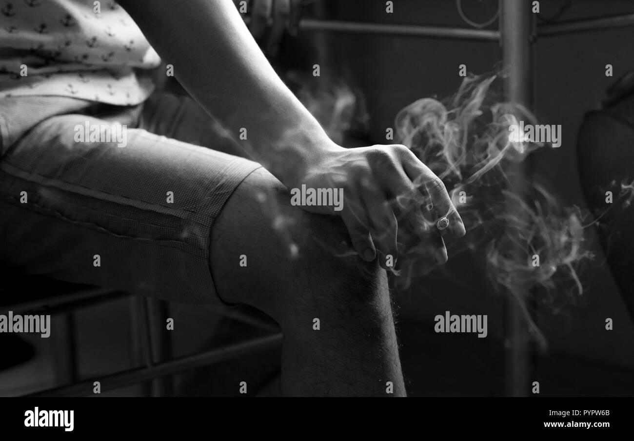 Photo en noir et blanc d'une adolescente tenant une cigarette. Banque D'Images
