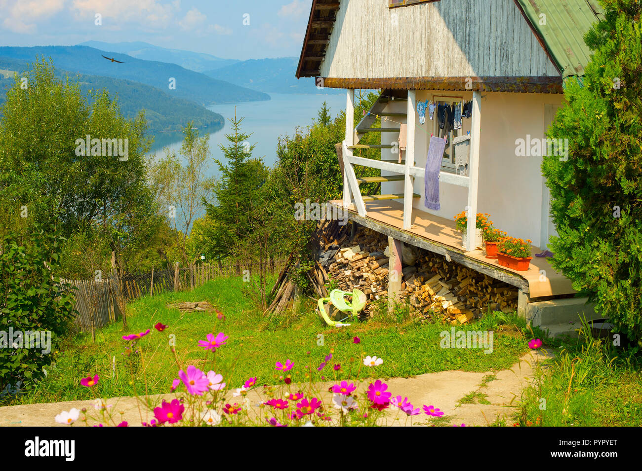 Scène avec maison roumaine typique en vert jardin fleuri par Muntelui mountain lake, Izvorul Muntelui, Neamt, Roumanie Banque D'Images