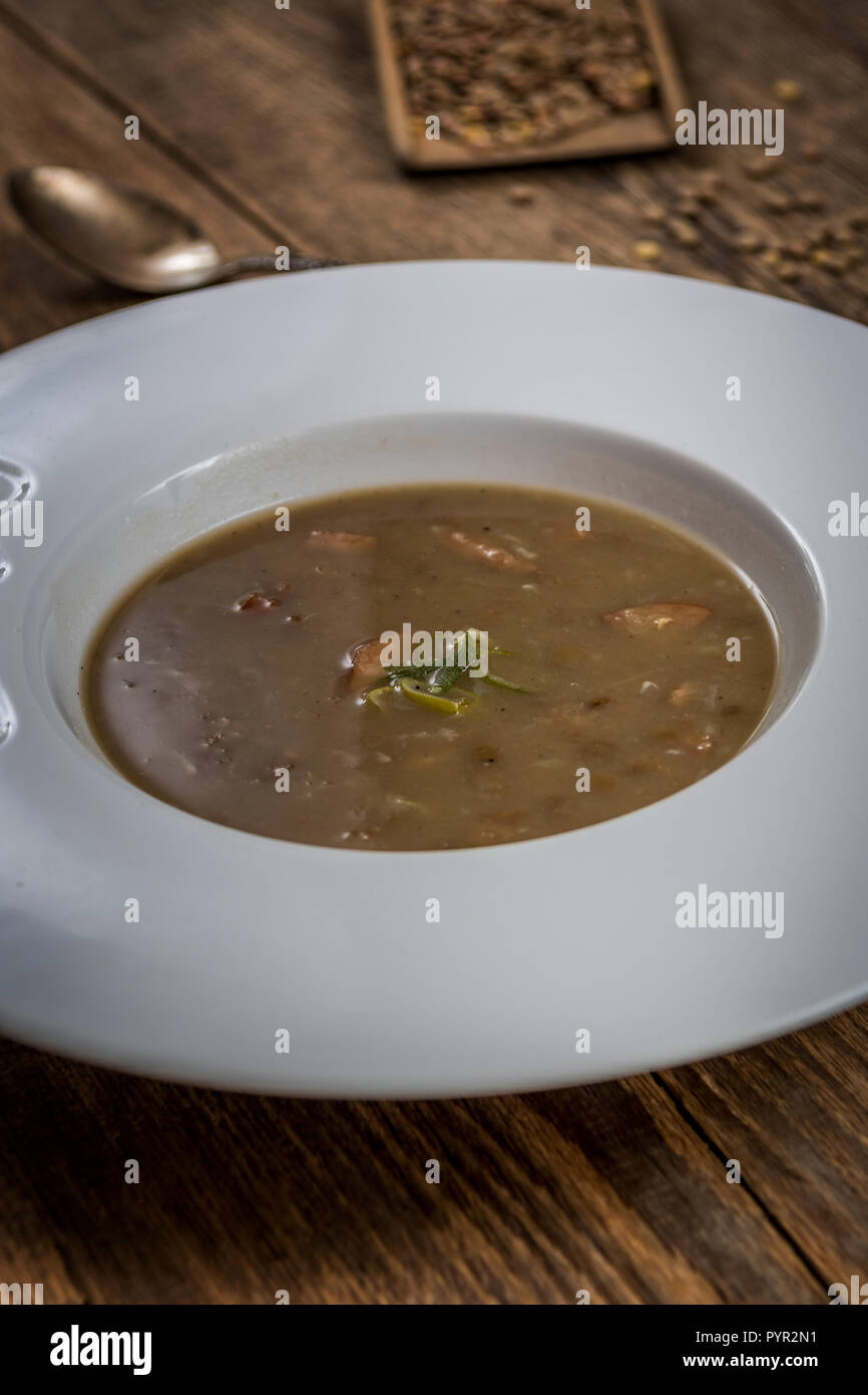 Lentilles brunes avec saucisse sop sur table en bois Banque D'Images