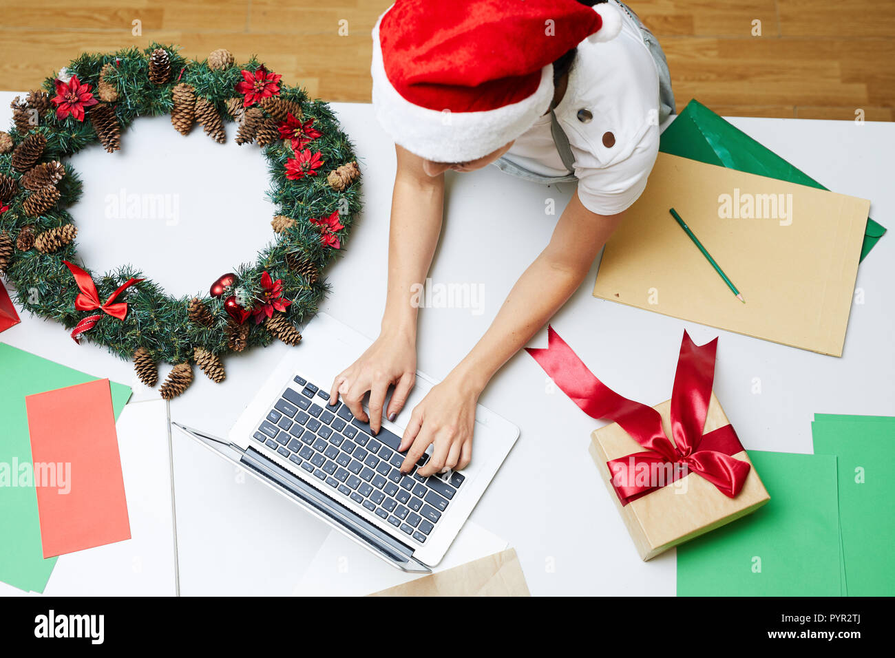 Woman in Santa hat typing on laptop Banque D'Images