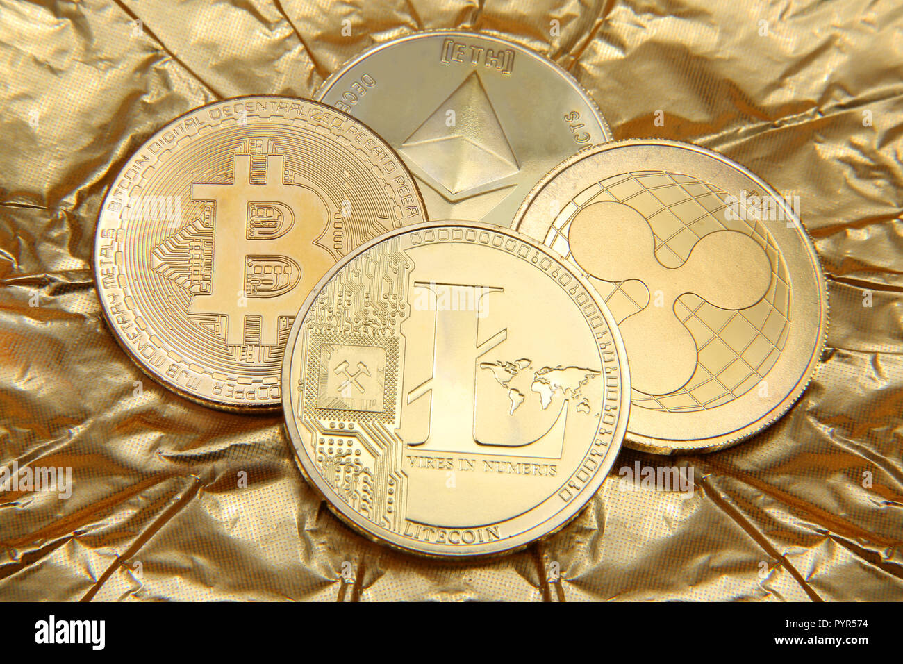 Litecoin, Ondulation, Ethereum Bitcoin et pièces d'or représentant les cryptocurrenies contre un fond d'or. Banque D'Images