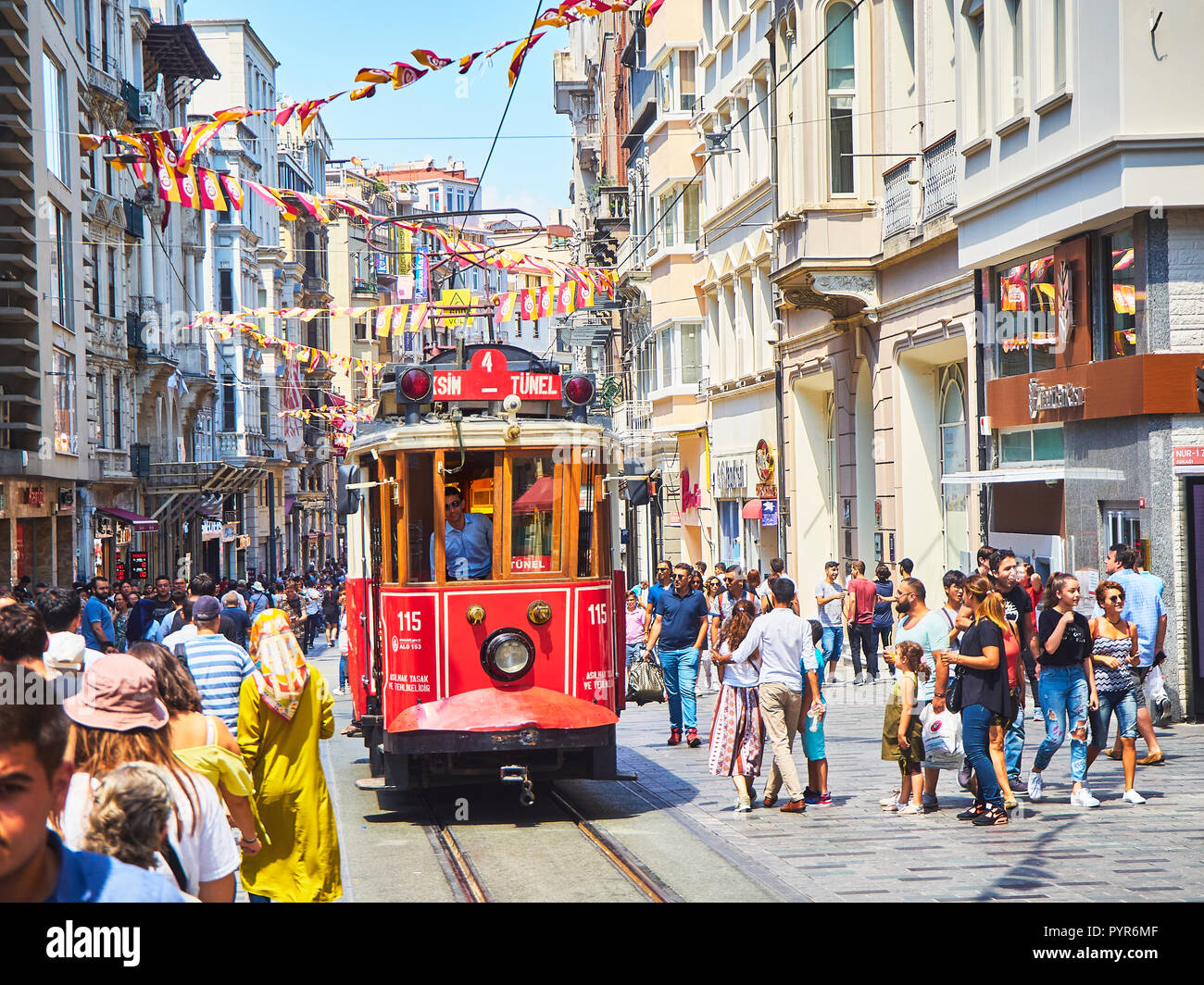 Un tram traversant la rue Istiklal animée, ornée de fanions du Club sportif de Galatasaray. Quartier de Beyoglu, Turquie. Banque D'Images