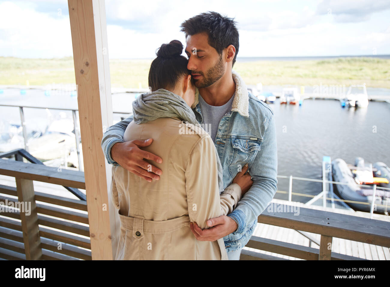 L'amour calme man hugging girlfriend à port maritime Banque D'Images