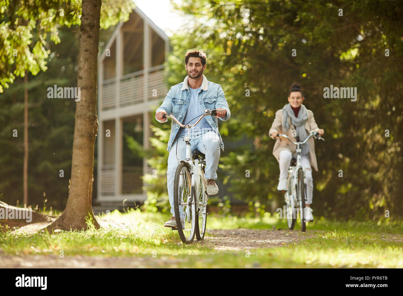 Heureux couple enjoying bike ride in forest Banque D'Images