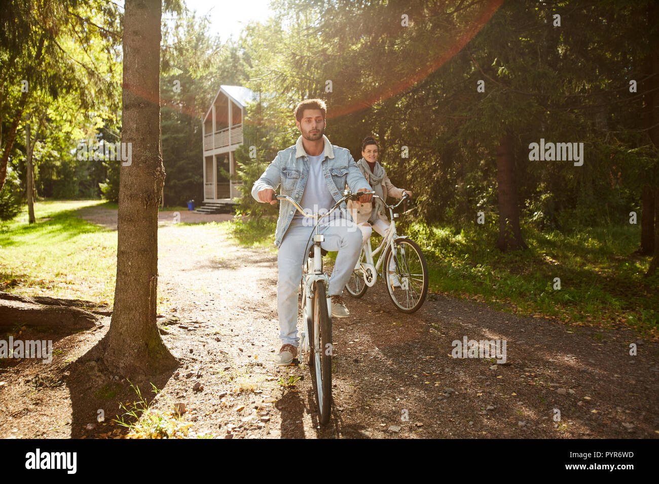 Couple actif riding bikes in forest Banque D'Images