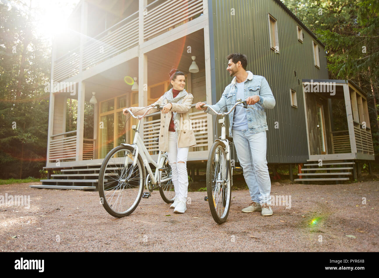 Jolly couple walking bicycles in countryside Banque D'Images