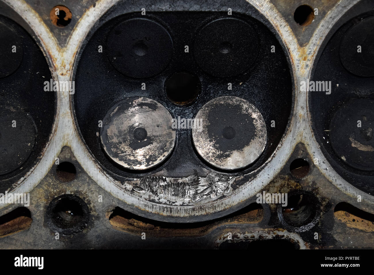 Soupape dans un dépôt sur le couvercle de la boîte de soupapes du moteur. Banque D'Images