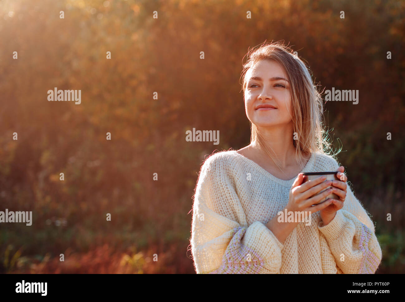 Belle admirant Femme buvant du thé chaud à partir de la Tasse thermos avec backligth soleil. Banque D'Images
