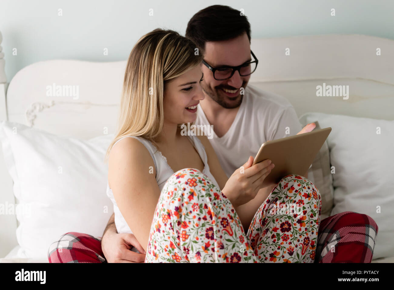Jeune beau couple using tablet dans la chambre Banque D'Images