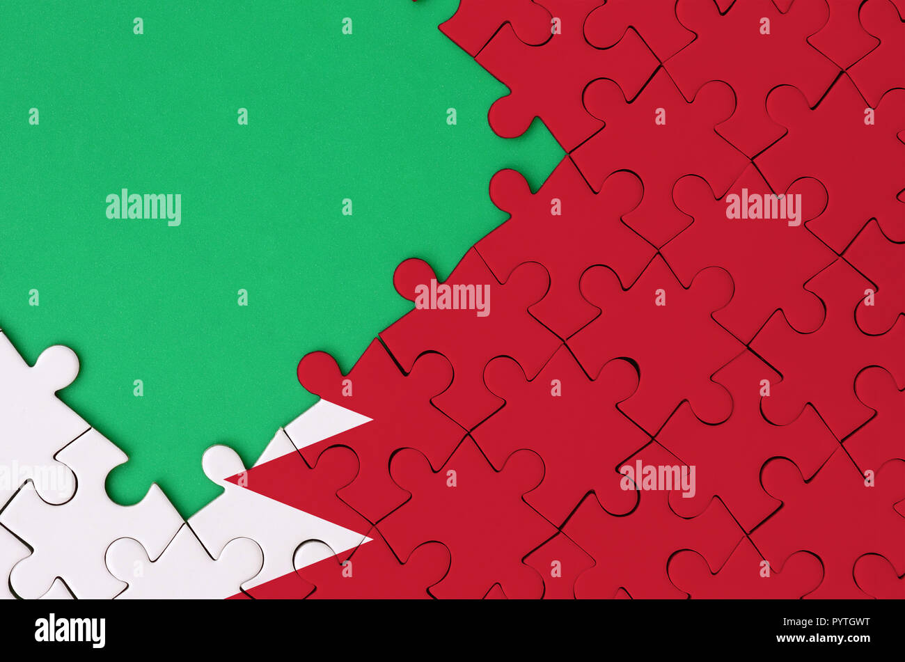 Drapeau de Bahreïn est représenté sur un puzzle avec copie espace vert sur le côté gauche. Banque D'Images
