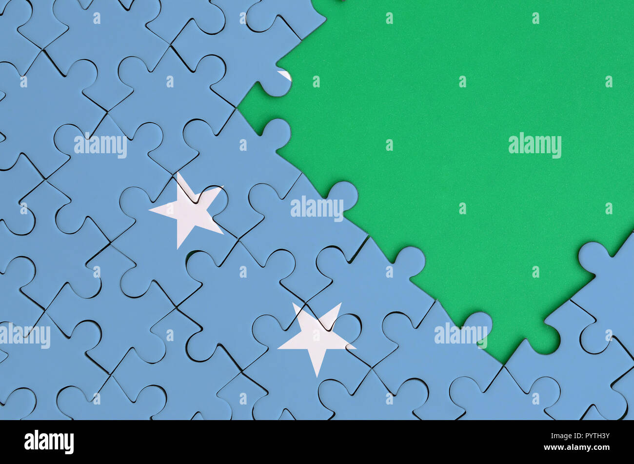 Micronésie drapeau est représenté sur un puzzle avec copie espace vert sur le côté droit. Banque D'Images