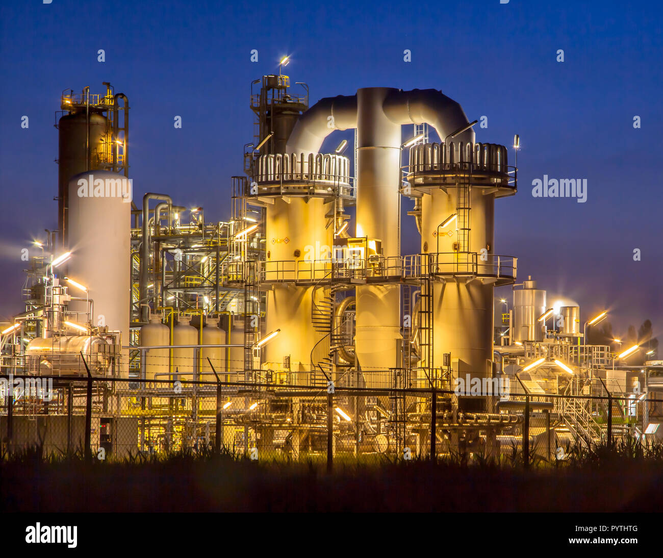 Scène de nuit d'un détail d'une installation industrielle chimique lourde avec mazework de tuyaux au crépuscule Banque D'Images
