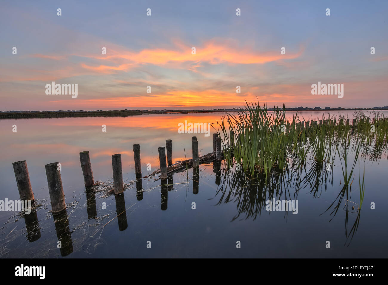 Coucher du soleil sur le lac avec la barrière de protection de la banque contre l'eau vagues pour créer une zone riveraine écologique naturel le long des lacs et des berges Banque D'Images