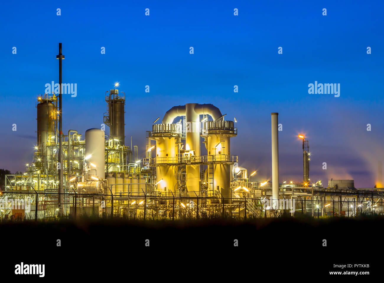 Scène de nuit d'une usine de produits chimiques industriels lourds avec mazework de tuyaux au crépuscule Banque D'Images