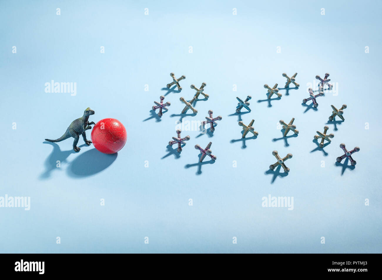 Photo conceptuelle du matériel roulant de dinosaures une boule rouge vers les prises d'antiquités. Banque D'Images