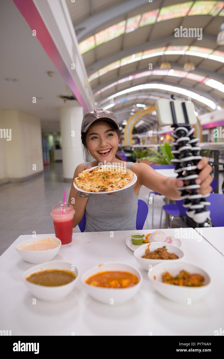 Jeune femme belle vlogging avec mobile phone in restaurant Banque D'Images