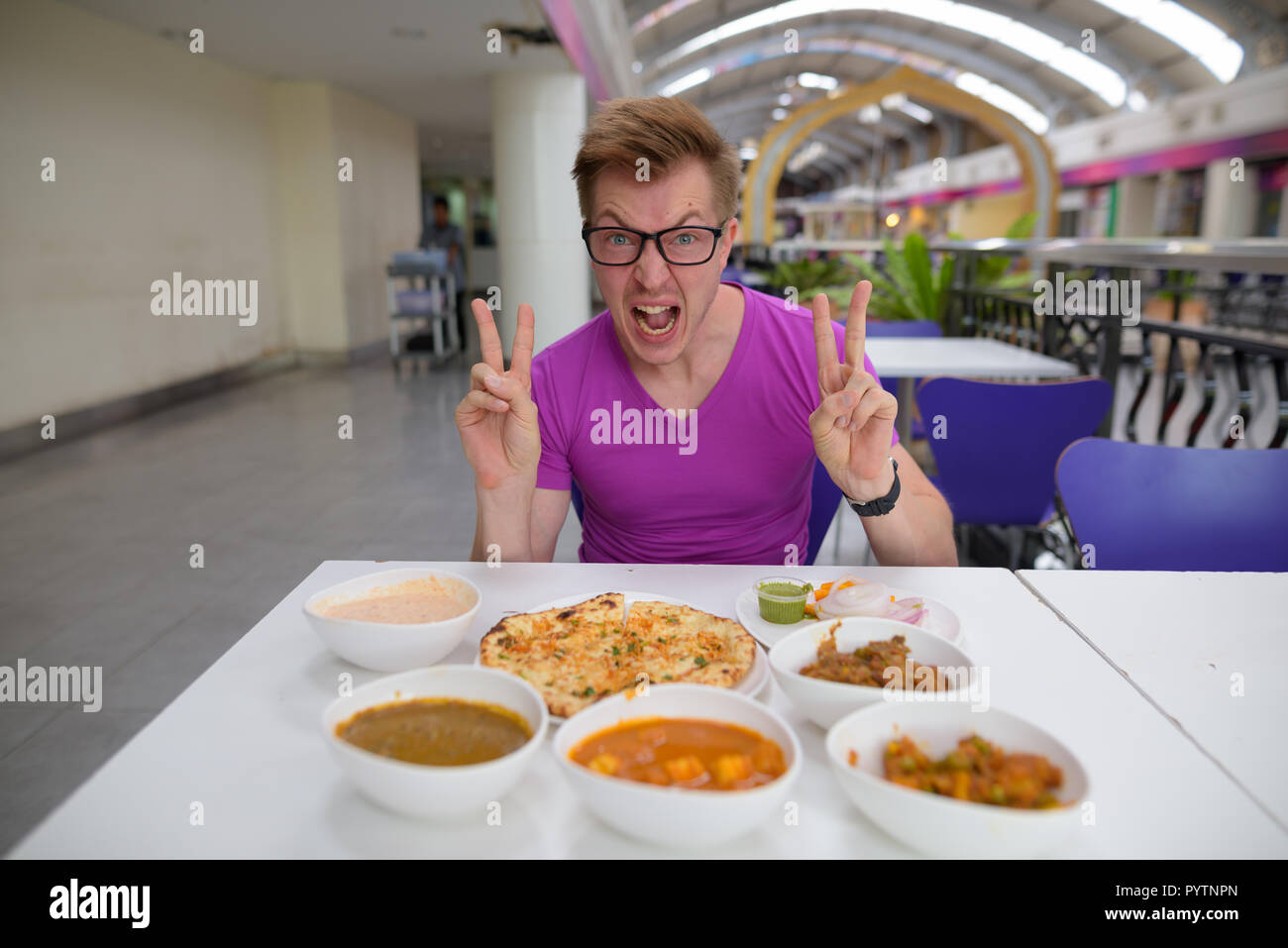 Beau jeune homme de tourisme bénéficiant d'une cuisine indienne à la restau Banque D'Images