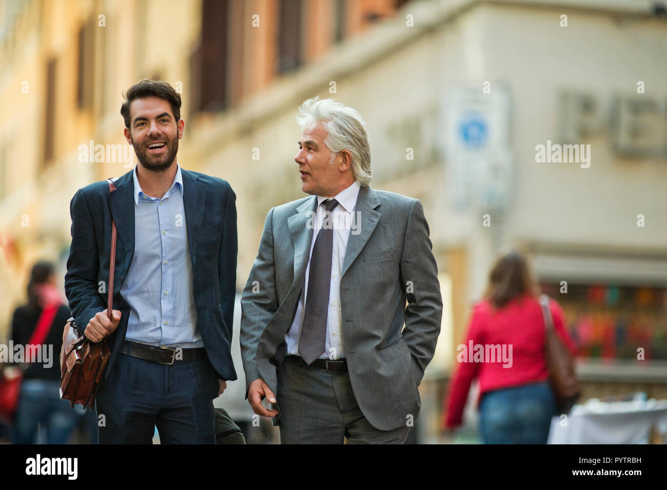 Mature businessman a une rencontre fortuite avec un jeune collègue, alors qu'ils sont dans la ville. Banque D'Images