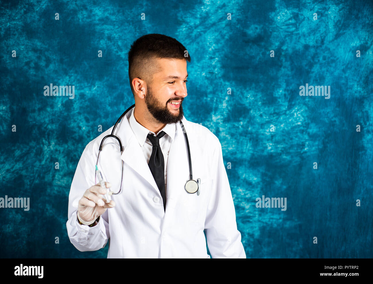 Handsome doctor holding a syringe close up portrait Banque D'Images