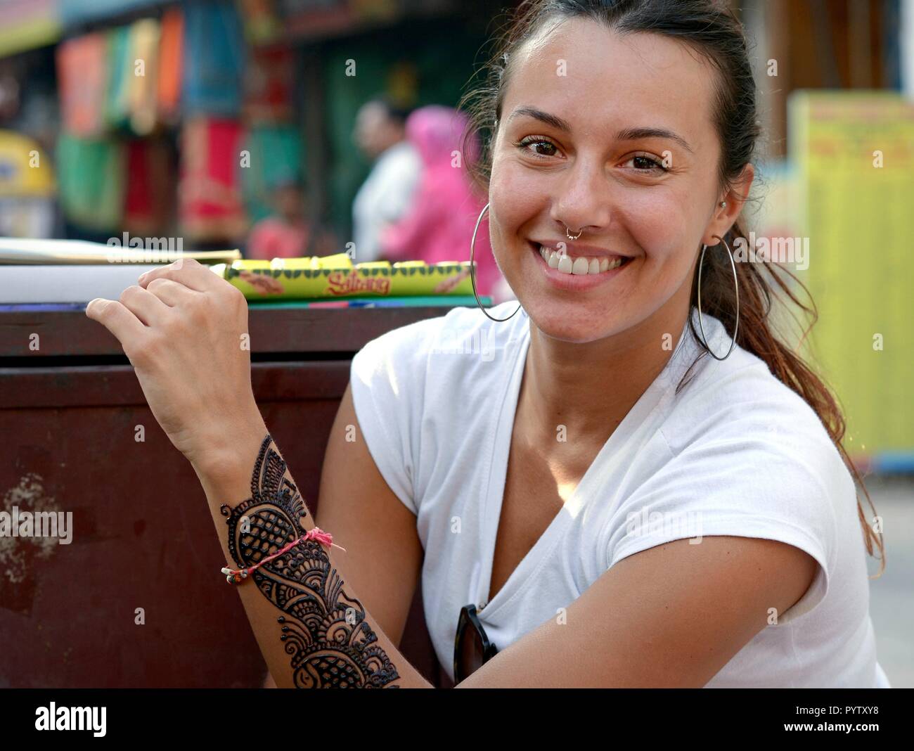 Les jeunes femmes d'Italie voyageur avec nez piercing montre son tout nouveau, encore humide et inachevé tatouage au henné traditionnel indien (mehendi). Banque D'Images