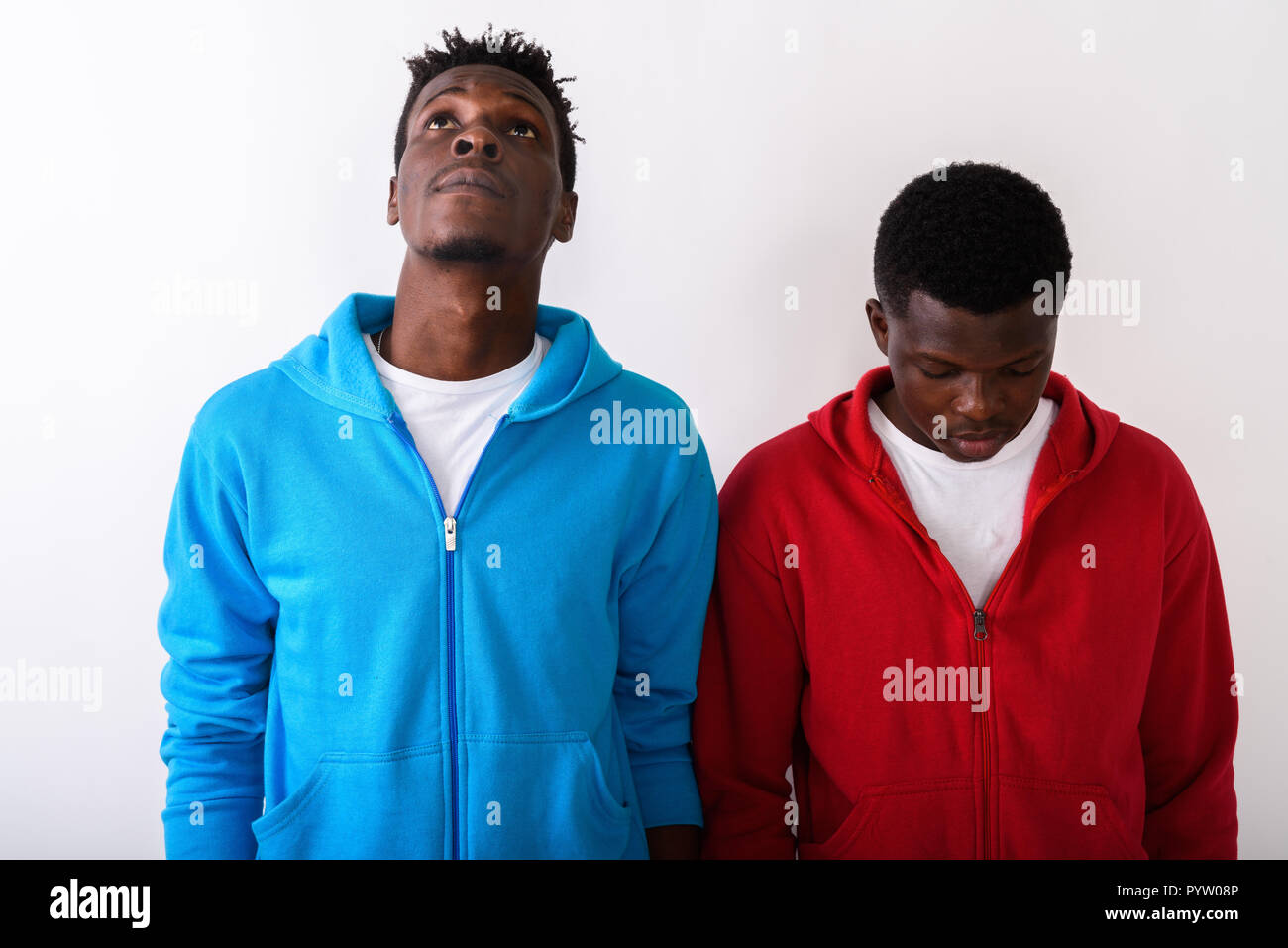 Studio shot of young slim black African man looking up avec youn Banque D'Images