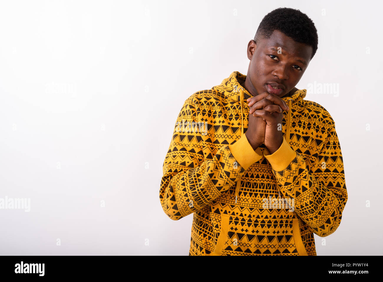 Studio shot of young black African man with hands together again Banque D'Images