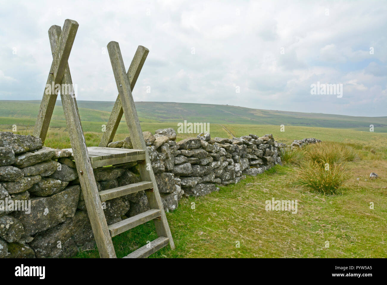 Mur en pierre sèche à Stonetor Hill sur le bord de Chagford commun sur le Dartmoor, avec Tor repousse rongeur au loin à l'ridge Banque D'Images